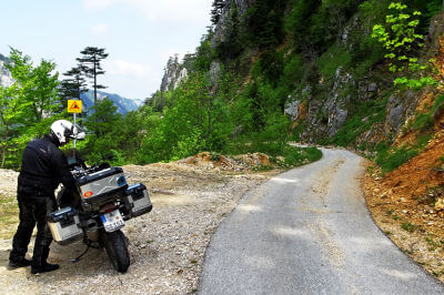 Motorrad parkt auf Seitenstreifen in gebirgiger Landschaft am Durmitorring