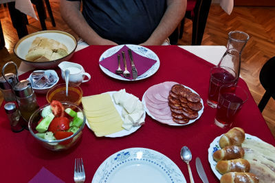 Reichlich gedeckter Frühstückstisch mit Käse und Wurst im Guesthouse Sandra