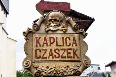 Schild mit Totenkopf und Aufschrift Kaplica Czaszek