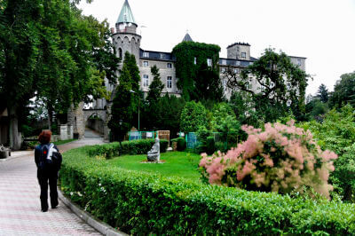 Frau läuft durch grünen Park der Burg von Szczytna