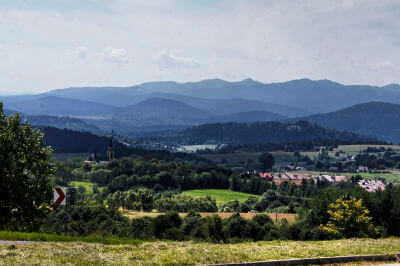 Panoramablick über die Landschaft in den Waldkarpaten mit Wiesen, Bäumen und im Hintergrund Berge