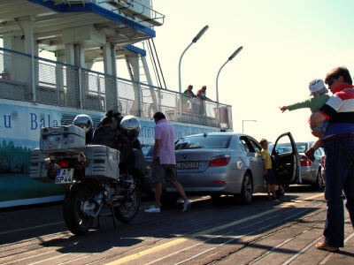 Motorrad steht mit Auto auf der Fähre über den Balaton