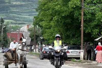 Motorrad überholt Pferdefuhrwerk in einem Dorf im Iza-Tal