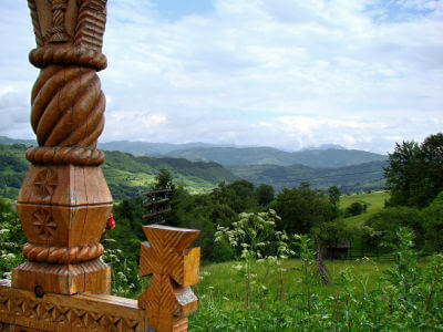 Blick an einem Holzdachpfosten vorbei auf das Panorama der Landschaft