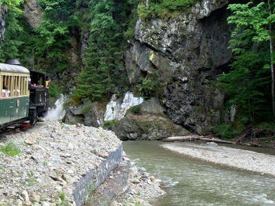 Die Wassertalbahn fährt am Flußbett in felsiger Landschaft