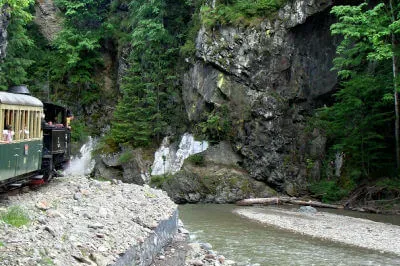 Die Wassertalbahn fährt am Flussbett in felsiger Landschaft