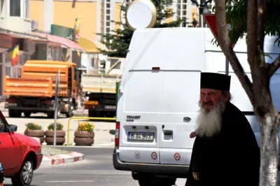 Straßenszene in Târgu Jiu Ein Geistlicher möchte hinter einem Lieferwagen die Straße in Târgu Jiu überqueren
