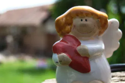 Unser Schutzengelchen ist auch in Rumänien immer dabei. Kleiner weißer Keramik-Schutzengel mit einem roten Herz in der Hand