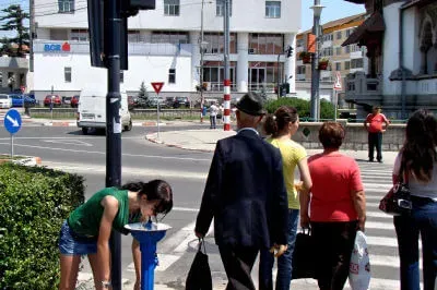 Überall in der Stadt sind die Wasserspender platziert. Mädchen trinkt an einem Wasserspender an der Hauptstraße in Târgu Jiu