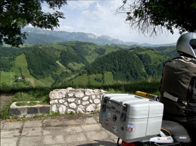 Blick über Motorrad auf die im Hintergrund liegenden bewaldeten Hügel des Bucegi-Gebirge