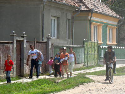 Unbefestigte Straße mit Einwohnern in einem Dorf in Transsilvanien