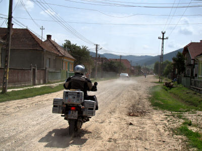 Motorrad fährt auf unbefestigter Straße eines Dorfes in Transsilvanien