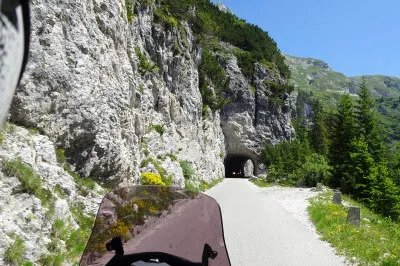 Immer wieder passieren wir unbeleuchtete Felstunnel. Da wünscht man sich dann, die Sonnenbrille nicht auf der Nase zu haben. Straße mit unbeleuchteten Felstunnel auf der Mangartstraße