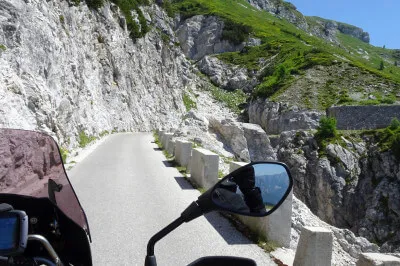 Atemberaubende Ausblicke - ein Motorradfahrer-Leckerbissen! Blick vom Motorrad auf die Straße mit atemberaubenden Ausblicken auf dem Mangart-Sattel