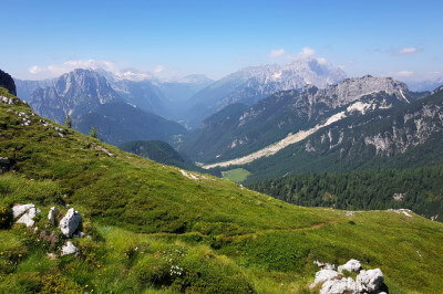 Talblick über grüne Wiese auf die slowenische Alpen von der Mangartstraße aus