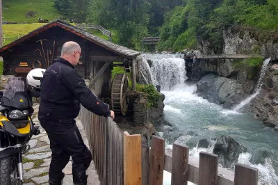 Islitzer Mühle in Hinterbichl, Virgental. Der Müller mahlt an zwei Tagen in der Woche. Motorradfahrer vor Islitzer Mühle in Hinterbichl im Virgental. Der Bach führt viel Wasser, aber das Mühlrad steht.