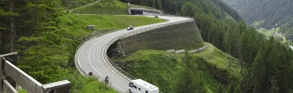 Auch wenn die Straße über das Tauerngebirge mit dem Tauerntunnel abgekürzt wurde, ist die ganze Streckenführung sehenswert. Serpentinenstraße mit Wohnmobil und Motorrad, Tauerntunnel