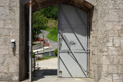 Blick durch das halb offene Eingangstor von Fort Kluze auf die Straße
