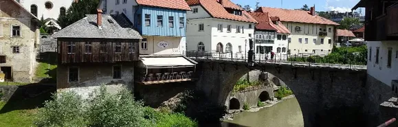 Die 600 Jahre alte Kapuzinerbrücke. Als der Erbauer, ein Bischof, eines Tages über die geländerlose Brücke ritt, scheute sein Pferd, worauf der Bischof in den Fluss stürzte und ertrank. Brücke und Jahrhunderte alte Häuser in Skofja Loka