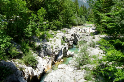 Soca, türkisfarbenes Wasser inmitten schroffer Felsen, auf den Felsen Badegäste und Sonnenanbeter