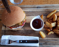 Hamburger und Pommes mit einer Ketchupsauce auf Holzbrett
