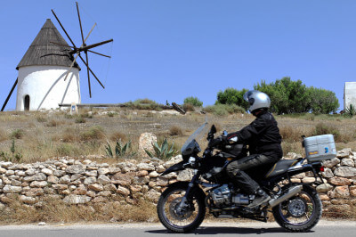 Windmühle mit Motorrad im Vordergrund auf Hügel