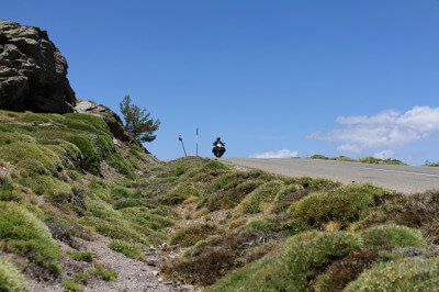 Motorradfahrer in der Ferne fährt über Bergkuppe in der Sierra de los Filabres
