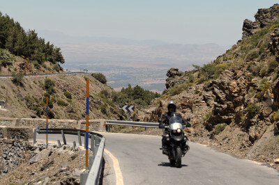 Motorrad fährt bergwärts zwischen Felsen am Puerto de la Ragua