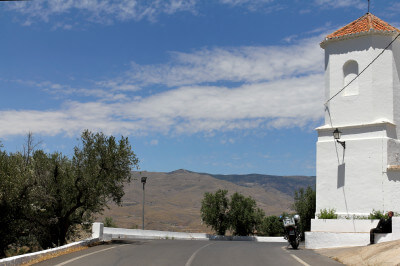 Weißer Turm erhebt sich rechts der Straße am Puerto de la Ragua