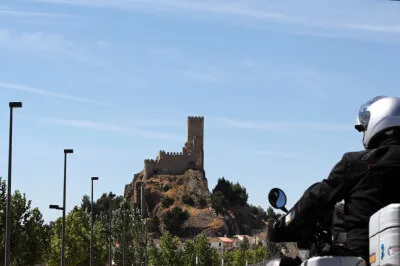 Das Castillo de Almansa, im 14. Jahrhundert von den Mauren als Militäranlage gebaut und nach der Rückeroberung zu ihrem heutigen Aussehen umgebaut wurde. Motorradfahrer blickt auf das hochstrebende Castillo de Almansa