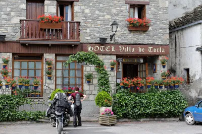 Unterwegs in der Sierra de los Filabres: einsam und allein auf der Straße! Motorrad steht vor dem begrünten Eingang zum Hotel Villa de Torla