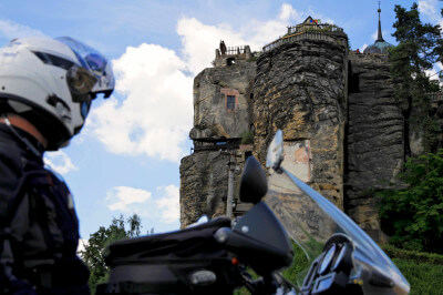 Motorradfahrer schaut hoch zur Burg Sloup v Čechách