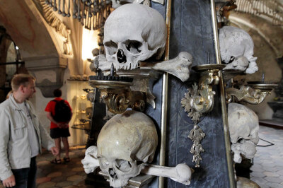 Schädel und Knochen aufgereiht auf einem Gestell im Gebeinhaus Sedlec