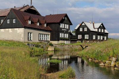 Typische Holzhäuser an einem Fluß in Jizerka