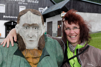 Frau umarmt eine Holzfigur vor der Berghütte Moravska BoudaElke