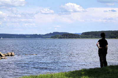 Frau steht am Ufer des Lipno-Stausees
