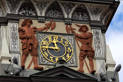 Zwei Skulpturen bewachen die Uhr am Rathaus in Prachatice