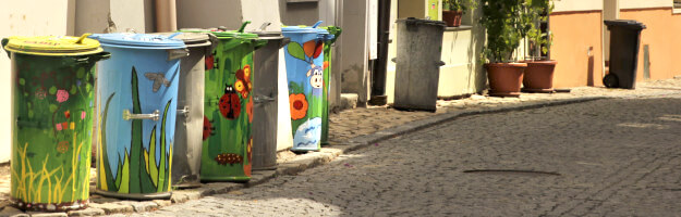 Eine ganze Reihe an der Straße stehende Mülltonnen kunstvoll bemalt in Tábor