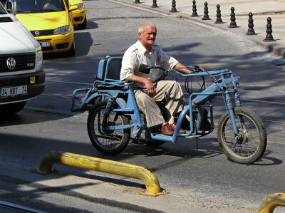 Mann sitzt in einem wohl behinderten gerechten Fahrzeug nahe der Galata-Brücke