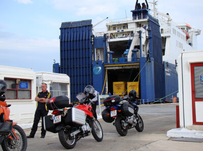 Mehrere Motorräder stehen vor dem Check-In im Hafen von Cesme