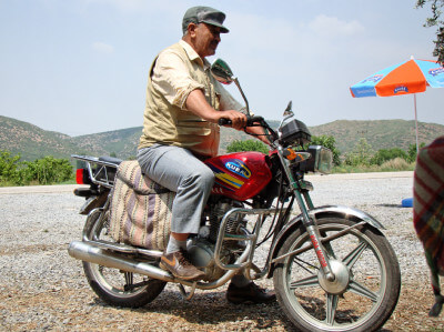 Ein türkischer Motorradfahrer sitzt auf seinem Motorrad auf einem Kelim
