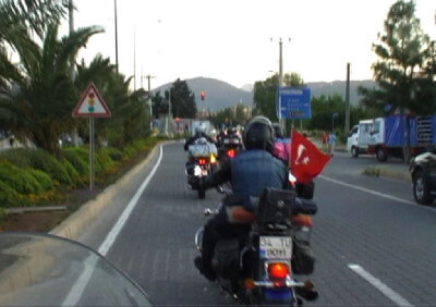 Mehrere Motorradfahrer fahren auf eine rote Ampel zu