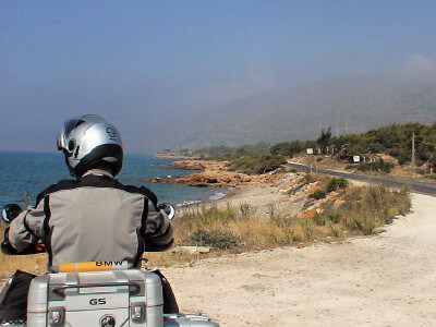 Motorrad steht auf Parkplatz direkt an der Mittelmeerküste