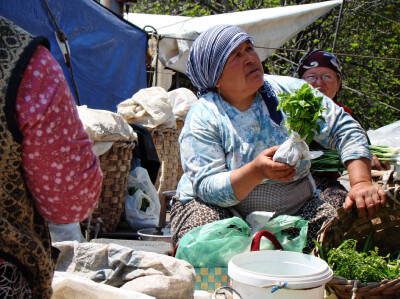 Marktfrau sitzt beim Verkauf von Gemüse auf dem Boden in Zonguldak