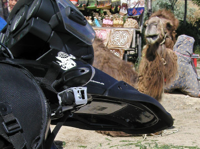 Motorrad steht vor am Boden liegenden Kamel bei einem Verkaufsstand in Kappadokien