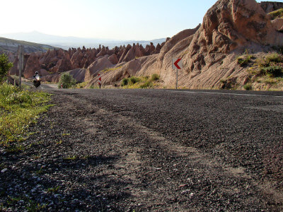 Motorrad fährt auf Straße durch die hügelige Landschaft in Kappadokien